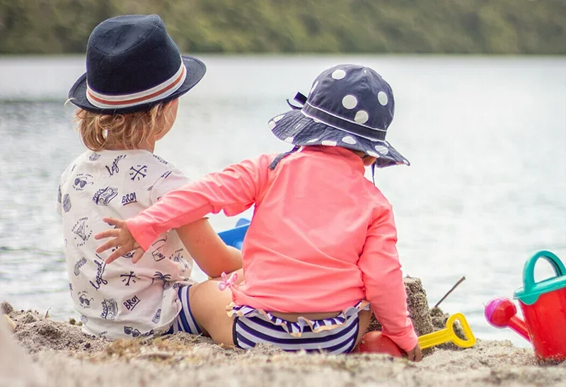 Two toddlers on a beach playing in sand - MAS Life Insurance - Homepage